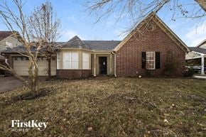 Memphis house for rent - the front of a brick house with a yard and a tree