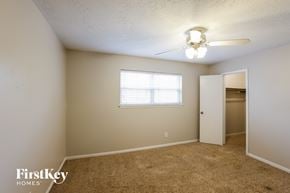 Spring house for rent - a bedroom with a closet and a ceiling fan