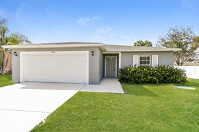 Port St. Lucie house for rent - a white house with a lawn and a garage door