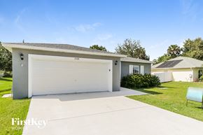 Port St. Lucie house for rent - a white house with a garage door and a lawn