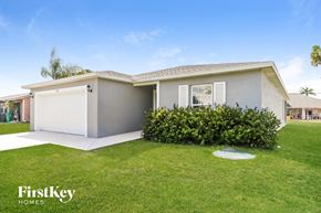 Port St. Lucie house for rent - a home with a lawn and a white garage door