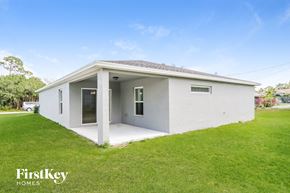 Port St. Lucie house for rent - a small white house with a porch and a grass yard