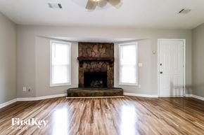 Duluth house for rent - a living room with a fireplace and wooden floors
