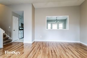 Duluth house for rent - an empty living room with a hard wood floor and a kitchen