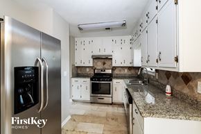 Duluth house for rent - a kitchen with white cabinets and stainless steel appliances