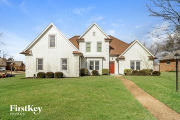 Memphis house for rent - a white house with a green lawn and a red door