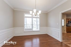 Matthews house for rent - an empty dining room with a window and a chandelier