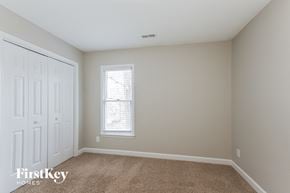 Matthews house for rent - a bedroom with a carpeted floor and a window and a closet