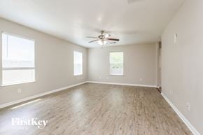 Houston house for rent - A spacious room with a ceiling fan and wooden flooring.