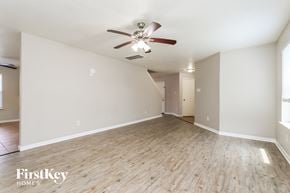Houston house for rent - A spacious room with a ceiling fan and wooden flooring.