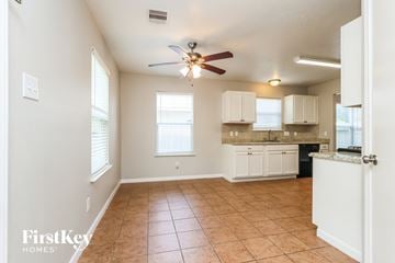 Houston house for rent - A kitchen area with a fan and cabinets.