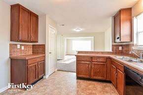 Indianapolis house for rent - a kitchen with wooden cabinets and a sink and a window