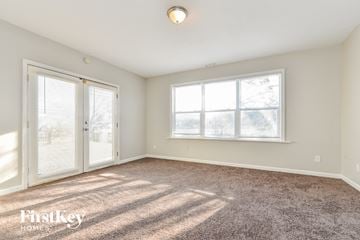 Indianapolis house for rent - a living room with carpet and two windows and a door