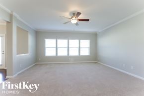 Charlotte house for rent - a empty living room with a ceiling fan and a window