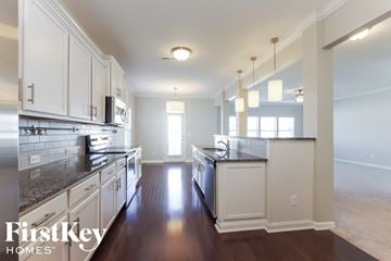 Charlotte house for rent - a large kitchen with white cabinets and granite counter tops