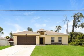 North Port house for rent - the front of a house with a driveway and a garage door