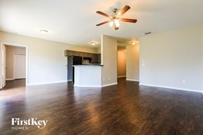 North Port house for rent - an empty living room with a ceiling fan and a kitchen