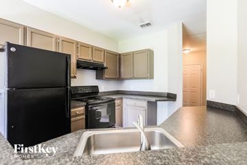North Port house for rent - a kitchen with granite counter tops and black appliances
