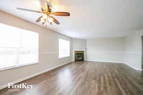 Plainfield house for rent - an empty living room with a ceiling fan and a fireplace