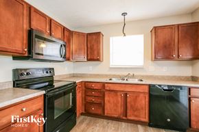 Plainfield house for rent - a kitchen with black appliances and wooden cabinets