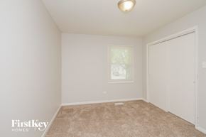 Plainfield house for rent - a bedroom with white walls and carpet and a door to a closet
