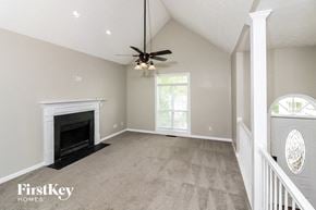 Marietta house for rent - an empty living room with a fireplace and a ceiling fan