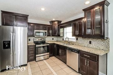 Marietta house for rent - a kitchen with wooden cabinets and stainless steel appliances