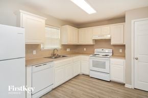 Texas City house for rent - A kitchen with white appliances and cabinets.