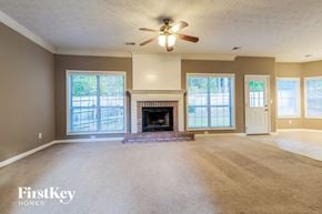 Dacula house for rent - an empty living room with a fireplace and a ceiling fan