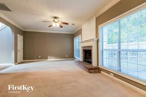 Dacula house for rent - an empty living room with a fireplace and a ceiling fan