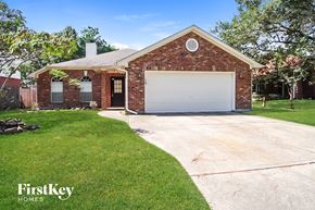 Humble house for rent - A brick house with a garage door is for sale.