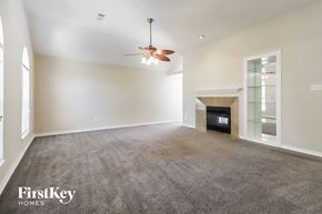 Humble house for rent - A spacious living room with a fireplace and a ceiling fan.