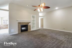 Humble house for rent - A spacious living room with a fireplace and a ceiling fan.