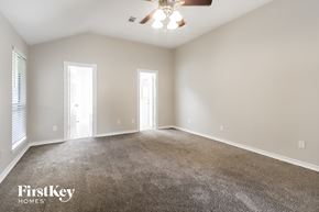 Humble house for rent - A spacious room with a carpeted floor and a ceiling fan.