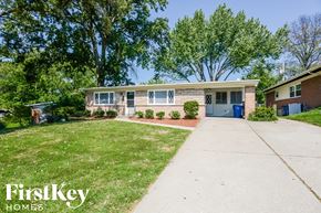 Florissant house for rent - a small brick house with a driveway and a blue door
