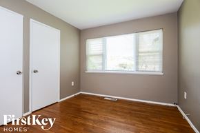 Florissant house for rent - a bedroom with wood floors and a window and a closet