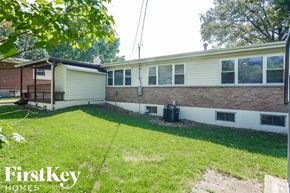 Florissant house for rent - the backyard of a brick house with a yard and grass