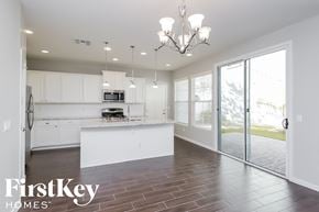 Mesa house for rent - a white kitchen with white cabinets and a sliding glass door