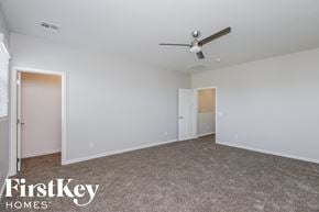 Mesa house for rent - a bedroom with white walls and a ceiling fan
