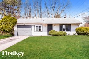 Indianapolis house for rent - A house with a garage and a lawn in front.