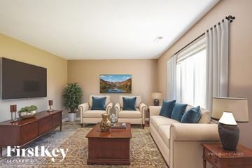 Indianapolis house for rent - A living room with a couch, a chair, a coffee table, and a painting on the wall.