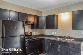 Indianapolis house for rent - A kitchen with black cabinets and a stainless steel refrigerator.