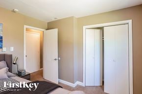 Indianapolis house for rent - A bedroom with a bed, nightstand, and two closets.