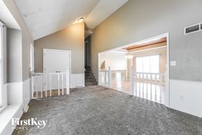 Blue Springs house for rent - a living room with a carpeted floor and a staircase