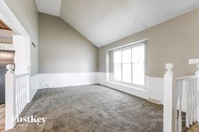 Blue Springs house for rent - a bedroom with a carpeted floor and a large window