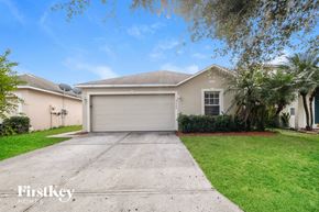 Winter Haven house for rent - a beige house with a driveway and a garage door