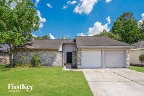 Spring house for rent - a white and gray brick house with a garage and a lawn