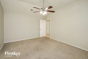 Spring house for rent - a bedroom with a ceiling fan and a carpeted floor