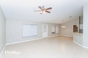 Palm Bay house for rent - A spacious empty room with a ceiling fan and a window.