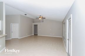 Palm Bay house for rent - A spacious room with a ceiling fan and light fixture.